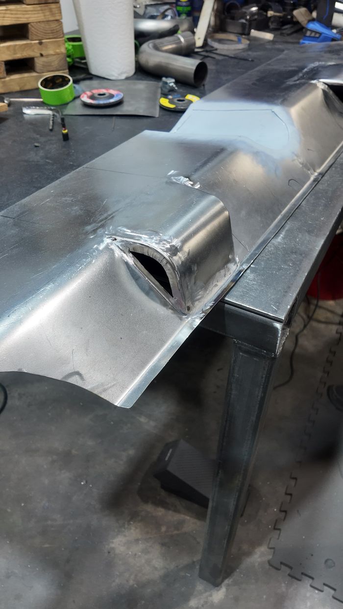 Close-up of a hand-fabricated sheet-metal section with a formed rectangular opening