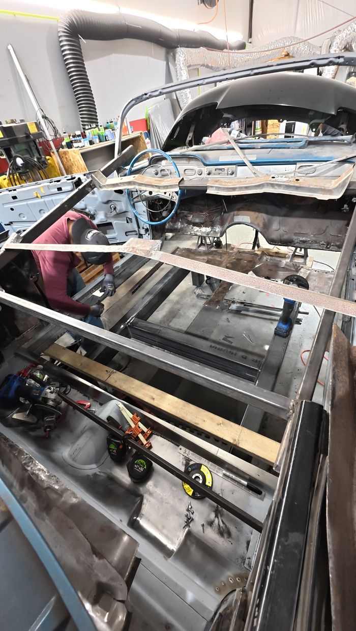 View forward through the Impala body from the trunk with floors removed and bracing bars across the openings